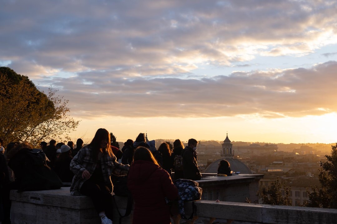 Diverse crowd networking at an evening community event on a rooftop terrace