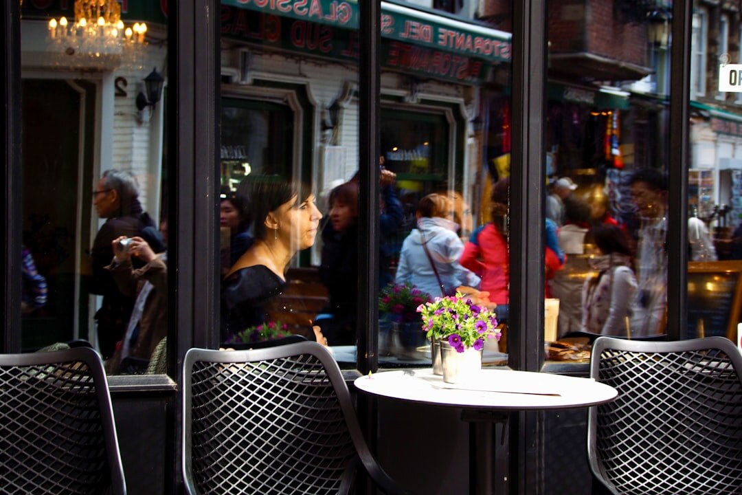 Diverse group of young adults laughing together in a cozy café in Belgium